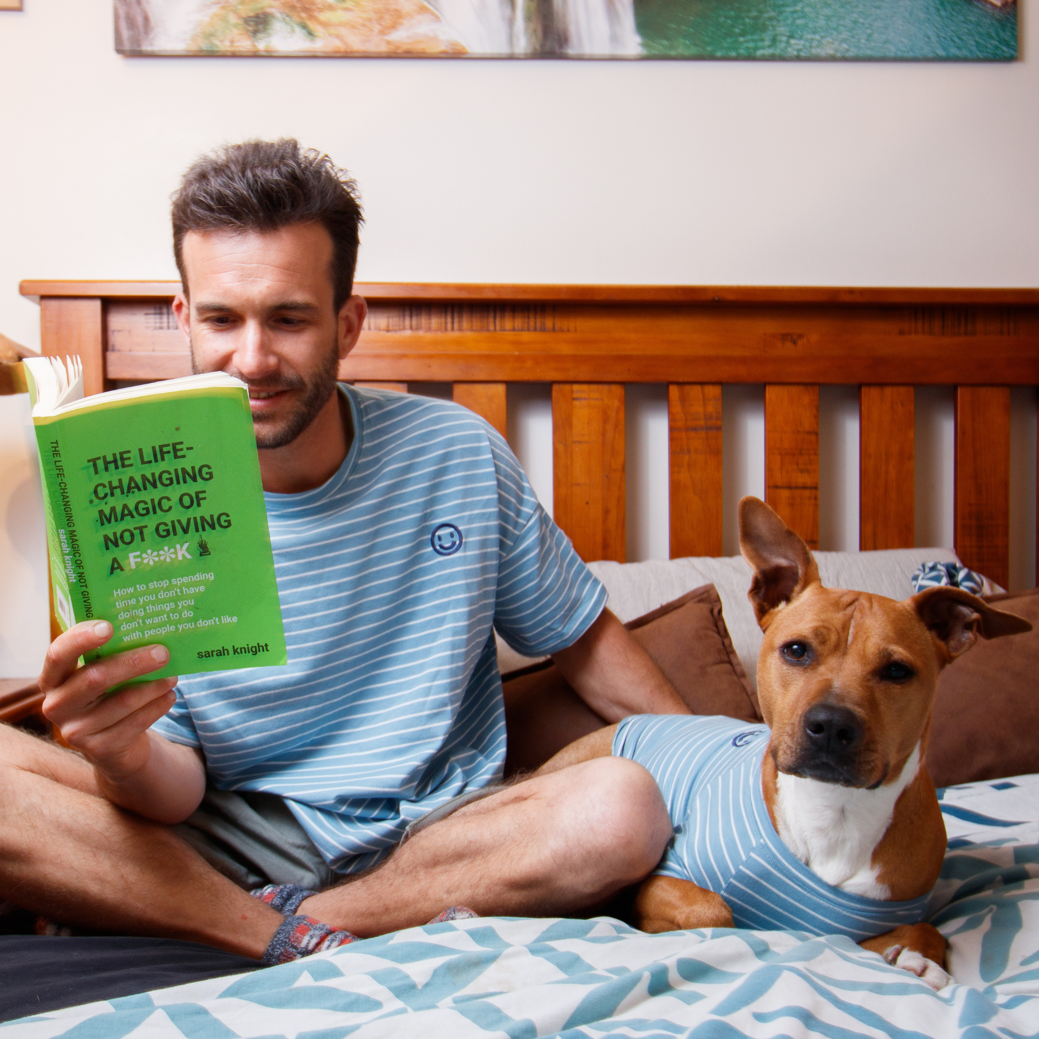 Stripped pijama outfit while dog reads book with owner